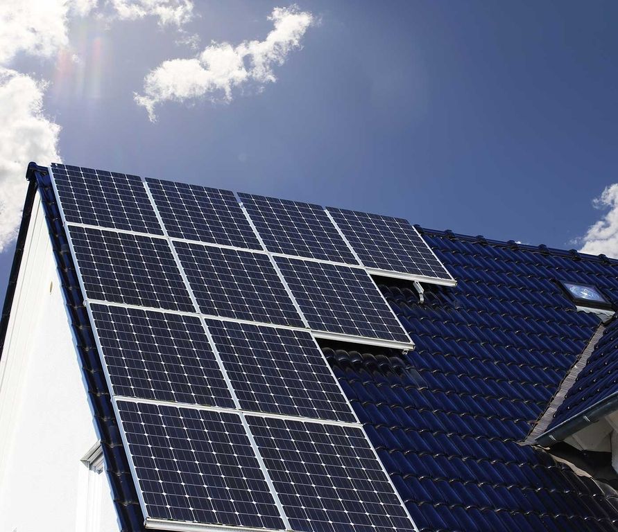 Ein Hausdach mit blauen Ziegeln und einer Solaranlage