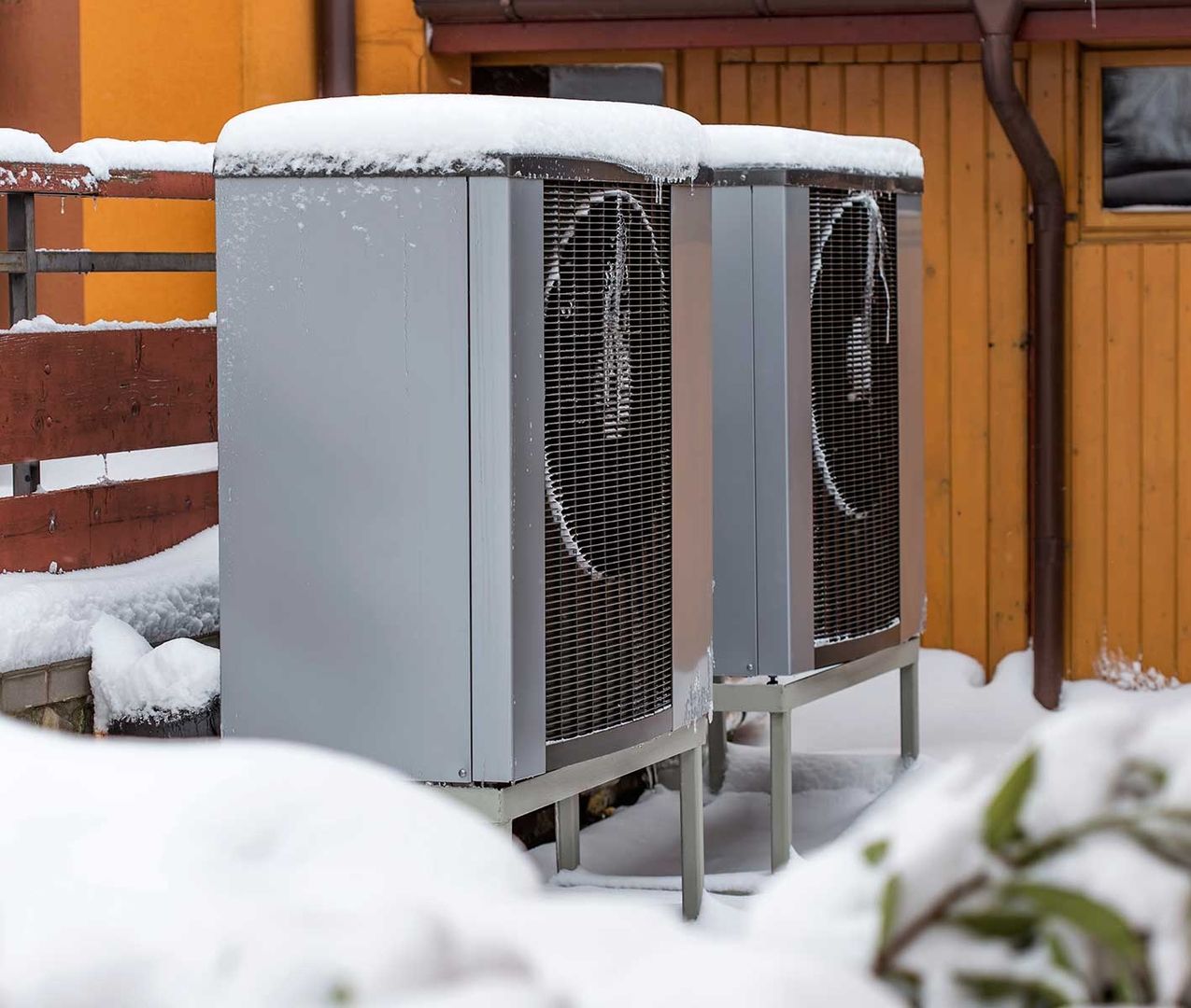 Eine Wärmepumpe außerhalb eines Hauses mit Schnee bedeckt